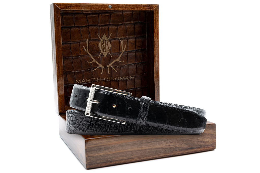 Genuine South African Ostrich Leg Leather Belt - Black Glazed in front of Martin Dingman Solid Wood Display Box