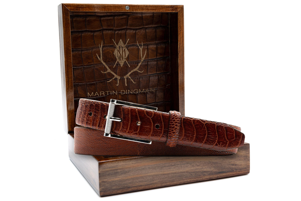 Genuine South African Ostrich Leg Leather Belt - Chestnut Glazed in front of Martin Dingman Solid Wood Display Box