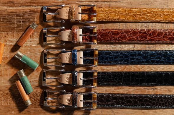 5 Wallace 2 Buckle Glazed Genuine Freshwater Crocodile Belts in the colors honey, chestnut, navy, black, and walnut
