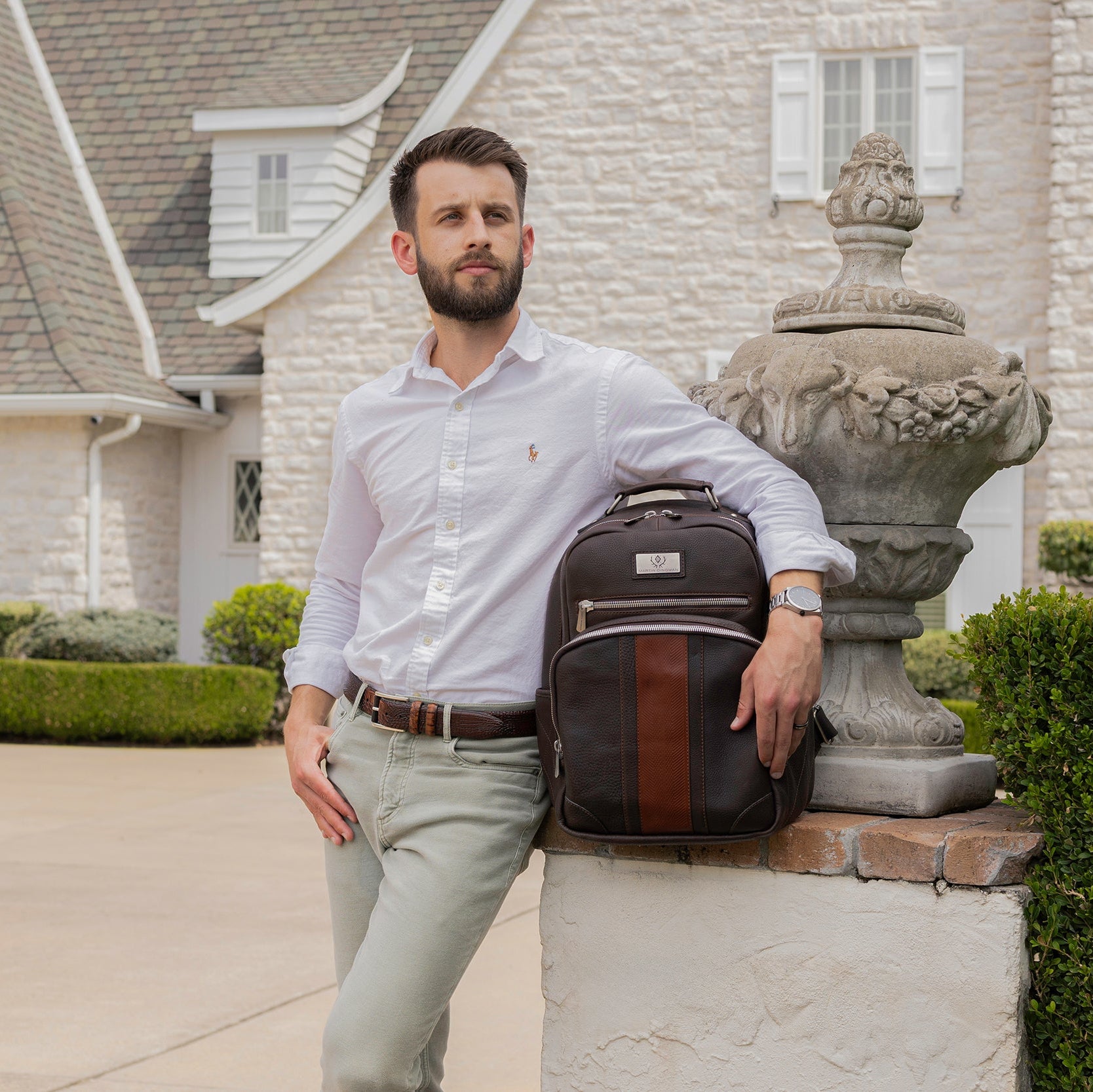 Man with a backpack standing in front of a house