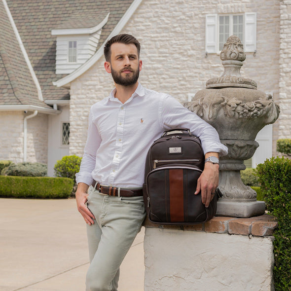 Man with a backpack standing in front of a house